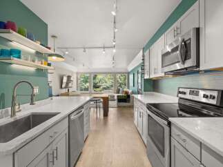Step into this stunning kitchen, featuring sleek countertops and modern appliances.