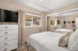 This inviting bedroom offers a serene retreat with its neutral color palette and ample natural light.