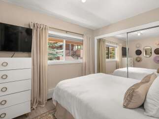 This inviting bedroom offers a serene retreat with its neutral color palette and ample natural light.