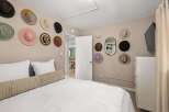This charming bedroom features a unique wall decor of hats, adding a touch of personality and style.