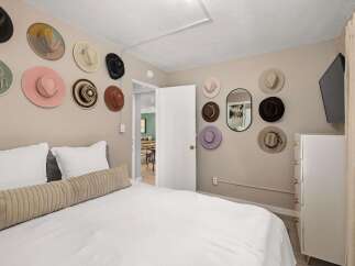 This charming bedroom features a unique wall decor of hats, adding a touch of personality and style.