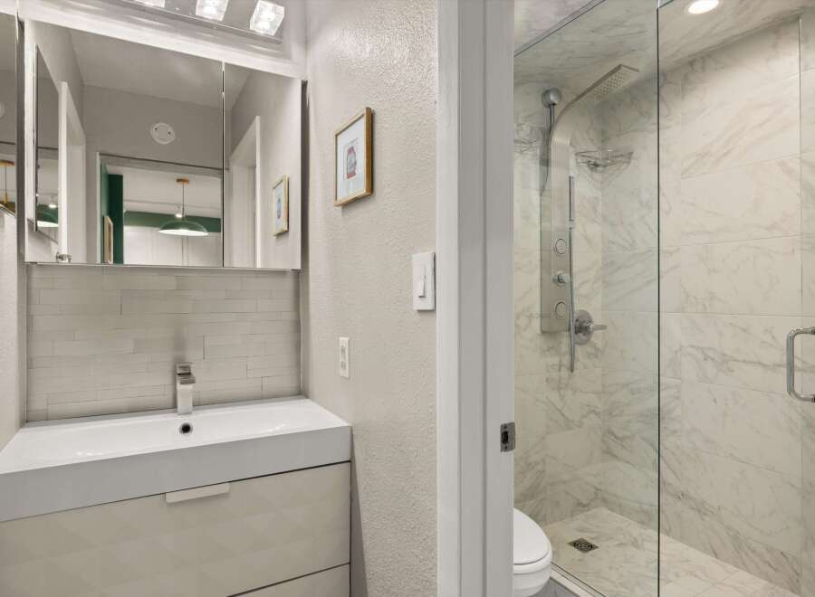 Step into a beautifully designed bathroom featuring a modern vanity and a luxurious glass-enclosed shower.