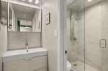 Step into a beautifully designed bathroom featuring a modern vanity and a luxurious glass-enclosed shower.