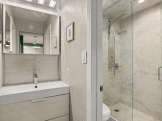 Step into a beautifully designed bathroom featuring a modern vanity and a luxurious glass-enclosed shower.