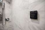 This luxurious bathroom features a modern steam bath control panel, perfect for unwinding after a long day.
