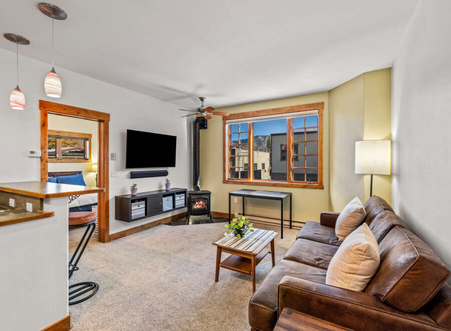 Step into this inviting living space, featuring a cozy fireplace and a stylish leather sofa, perfect for relaxing evenings.