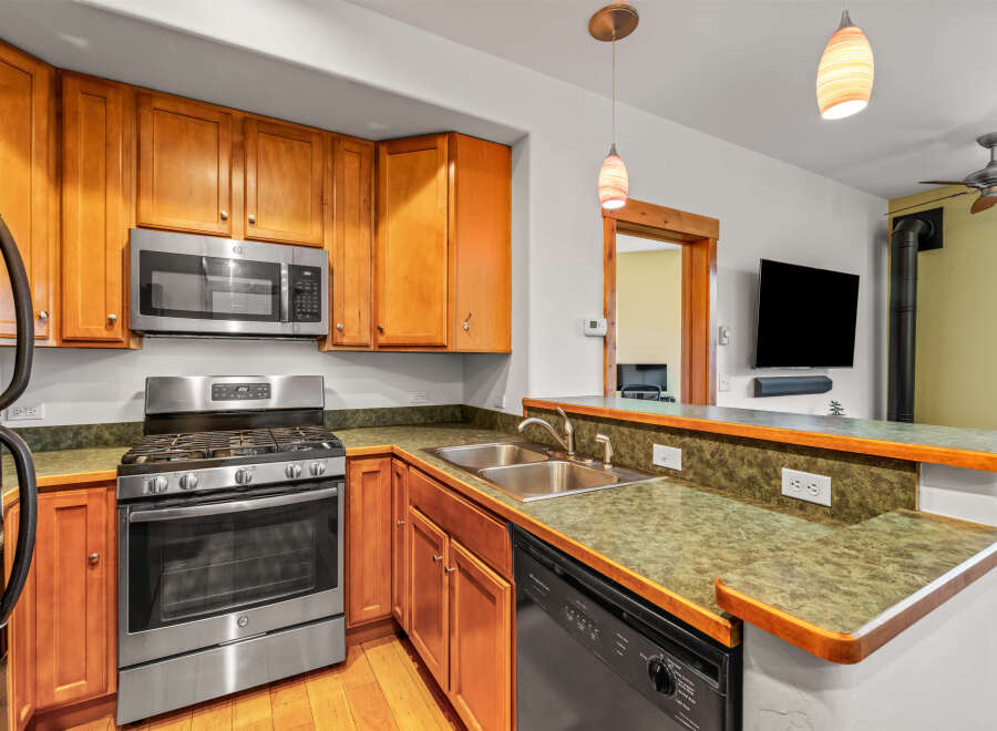 This stunning kitchen boasts beautiful wooden cabinetry and modern stainless steel appliances, creating a warm and inviting atmosphere.