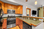 This stunning kitchen boasts beautiful wooden cabinetry and modern stainless steel appliances, creating a warm and inviting atmosphere.