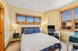 This cozy bedroom offers a comfortable retreat with its inviting ambiance and natural light.