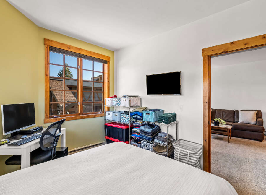 This inviting bedroom features a cozy atmosphere with a comfortable bed and a well-lit workspace.