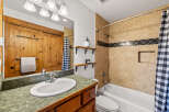 This charming bathroom features a rustic wooden vanity and a stylish checkered shower curtain.
