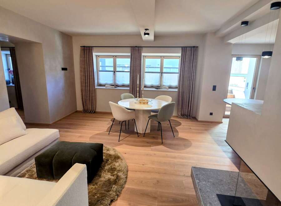 Experience modern elegance in this stunning living space, featuring a cozy seating area and a stylish dining setup.