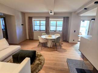 Experience modern elegance in this stunning living space, featuring a cozy seating area and a stylish dining setup.