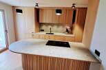 This modern kitchen boasts a sleek design with a large island featuring a cooktop and ample counter space.