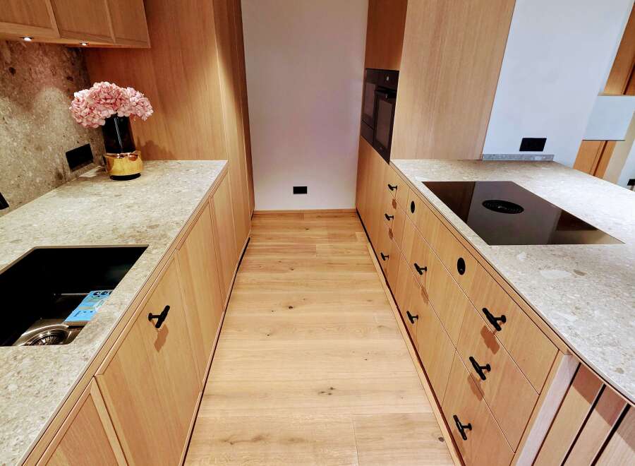 This modern kitchen showcases a sleek design with light wood cabinetry and countertops.