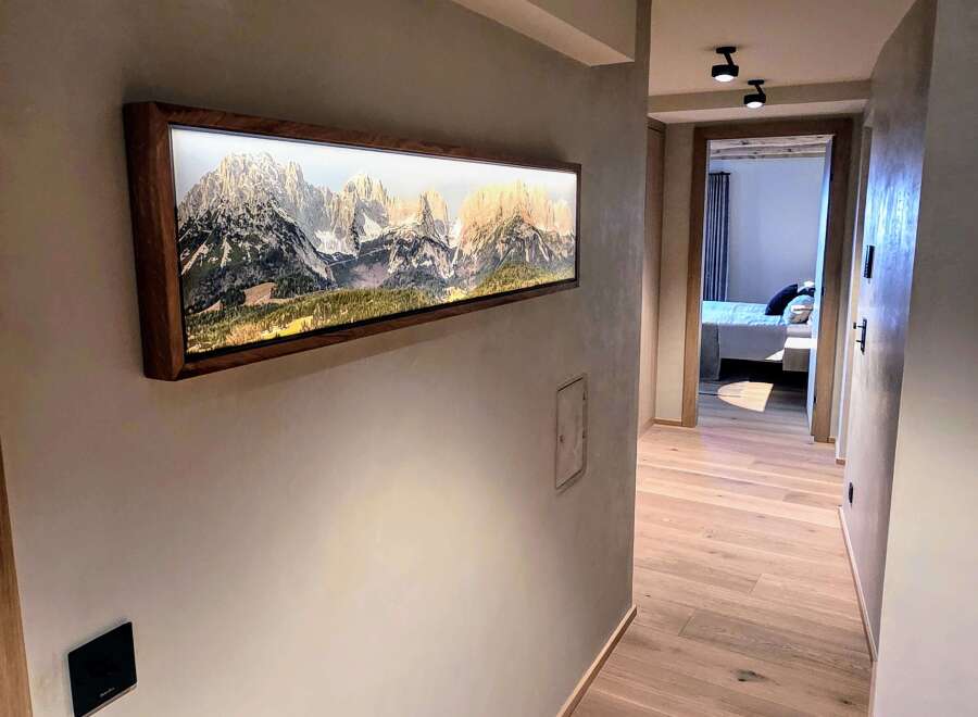 This stunning hallway showcases a modern design with a beautiful mountain landscape artwork.