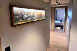 This stunning hallway showcases a modern design with a beautiful mountain landscape artwork.