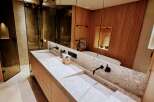 This luxurious bathroom boasts a sleek, modern design with a double vanity featuring a stunning stone countertop.