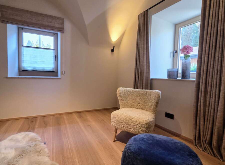 This cozy room features a comfortable chair and a stylish ottoman, perfect for relaxation.