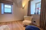 This cozy room features a comfortable chair and a stylish ottoman, perfect for relaxation.