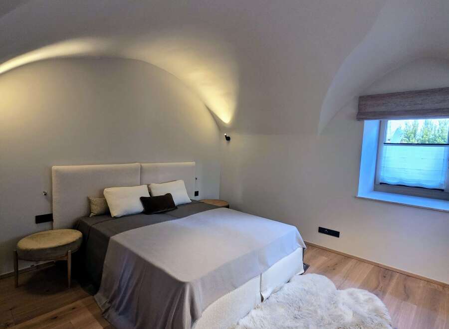 This cozy bedroom features a comfortable bed with a plush rug, perfect for relaxing.