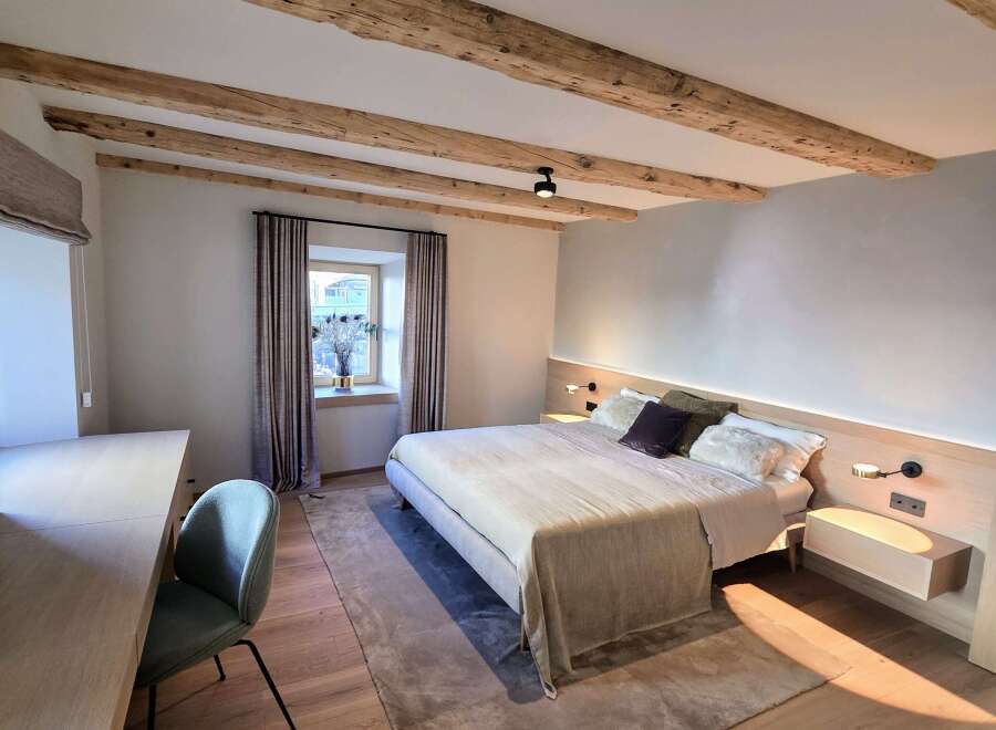 Experience the charm of this beautifully designed bedroom, featuring exposed wooden beams that add a touch of rustic elegance.