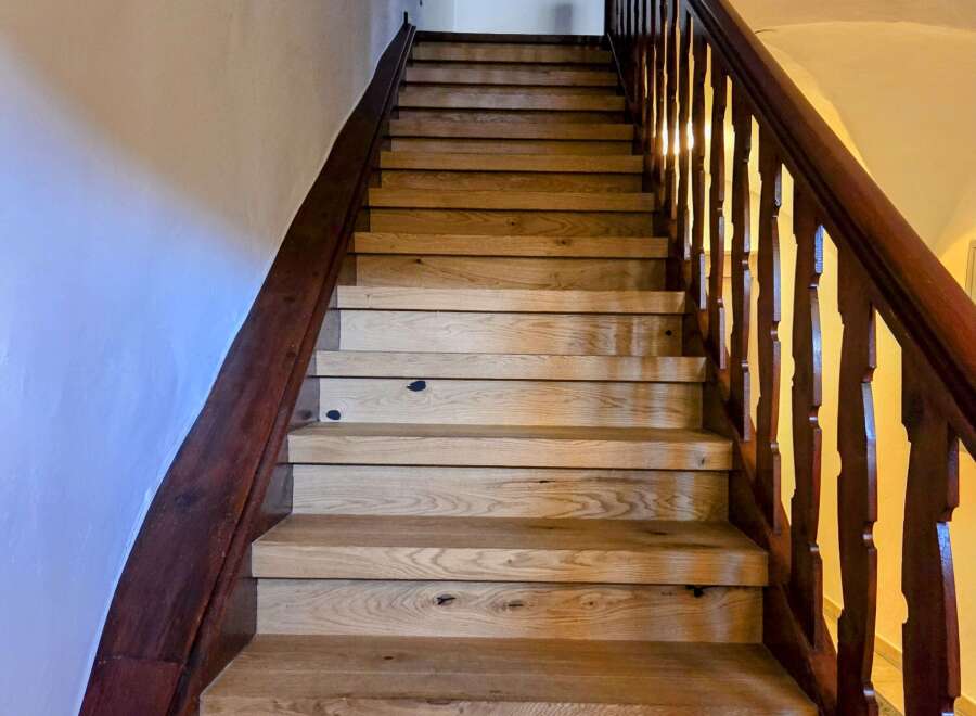 This stunning staircase is a focal point of the home, featuring beautiful wooden steps and a rich, dark wood railing.