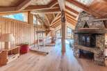 This stunning property boasts a rustic charm with its wooden interior and a cozy fireplace, perfect for a relaxing retreat.
