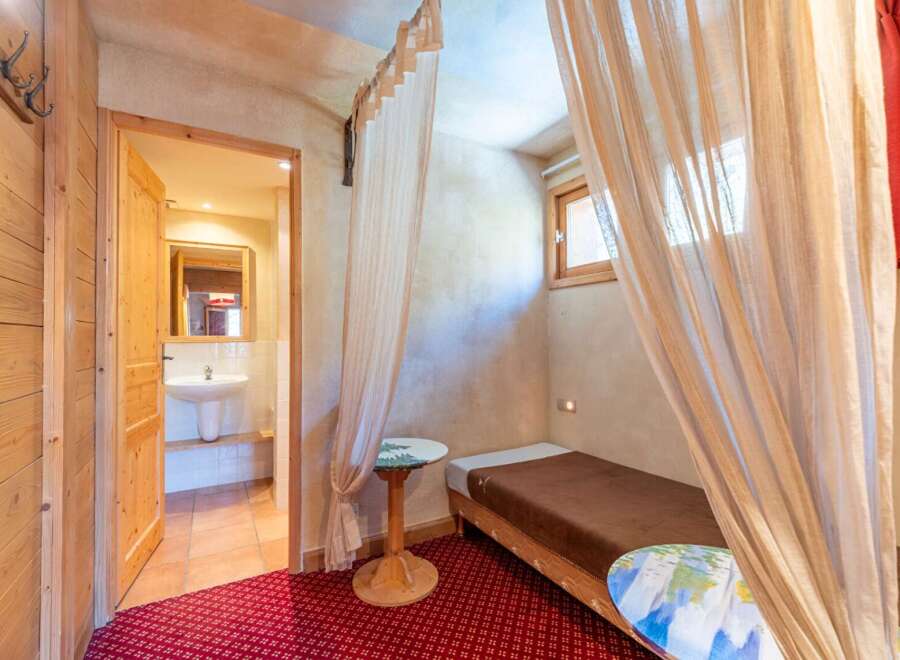 Discover the charm of this cozy property, featuring a unique bedroom design with elegant curtains and a comfortable single bed.