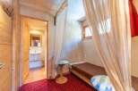 Discover the charm of this cozy property, featuring a unique bedroom design with elegant curtains and a comfortable single bed.