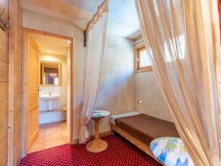 Discover the charm of this cozy property, featuring a unique bedroom design with elegant curtains and a comfortable single bed.