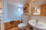This charming bathroom features a cozy, rustic design with wooden accents and a bright, inviting atmosphere.