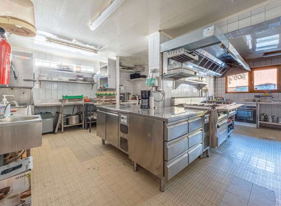 This commercial kitchen is a chef's dream, featuring stainless steel appliances and ample counter space for food preparation.