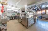 This commercial kitchen is a chef's dream, featuring stainless steel appliances and ample counter space for food preparation.