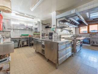 This commercial kitchen is a chef's dream, featuring stainless steel appliances and ample counter space for food preparation.