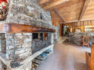 Experience rustic charm in this stunning property featuring a magnificent stone fireplace, perfect for cozy evenings.