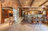 Step into a charming bar area with rustic wooden accents and a stone facade, creating a warm and inviting atmosphere.