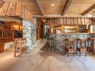 Step into a charming bar area with rustic wooden accents and a stone facade, creating a warm and inviting atmosphere.
