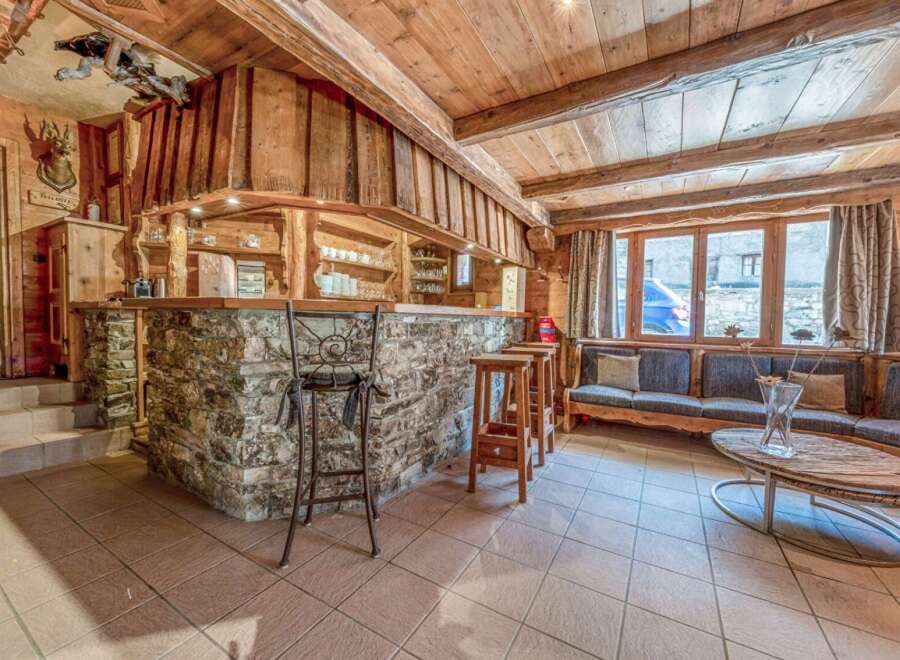 This stunning property boasts a rustic charm with its wooden interior and stone accents.