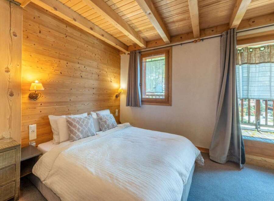 Experience the warmth of this cozy bedroom, featuring stunning wood paneling and a charming ambiance.