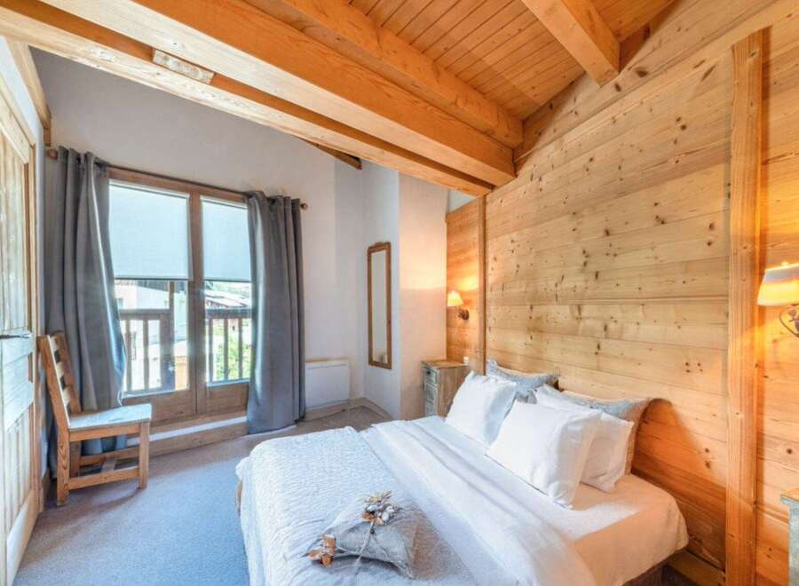 Experience the charm of this cozy bedroom featuring a rustic wooden ceiling and walls, creating a warm and inviting atmosphere.