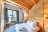 Experience the charm of this cozy bedroom featuring a rustic wooden ceiling and walls, creating a warm and inviting atmosphere.