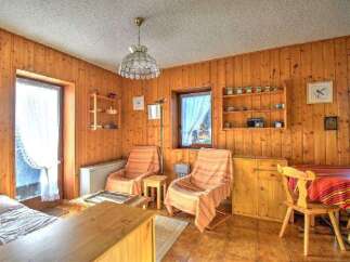 Step into a cozy retreat with this charming property, featuring warm wooden paneling throughout.
