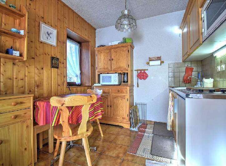 Step into this charming kitchen, featuring warm wooden cabinetry and paneling that exudes a cozy, inviting atmosphere.