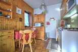 Step into this charming kitchen, featuring warm wooden cabinetry and paneling that exudes a cozy, inviting atmosphere.