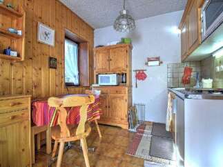 Step into this charming kitchen, featuring warm wooden cabinetry and paneling that exudes a cozy, inviting atmosphere.