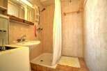 Step into this cozy bathroom, featuring a practical shower area and a functional sink.