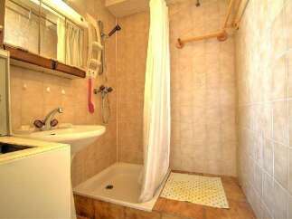 Step into this cozy bathroom, featuring a practical shower area and a functional sink.