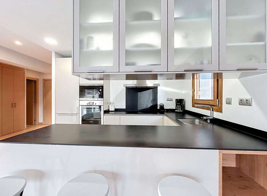 Discover modern living in this stylish kitchen! Featuring sleek cabinetry, a black countertop, and stainless steel appliances, this space is perfect for cooking and entertaining.