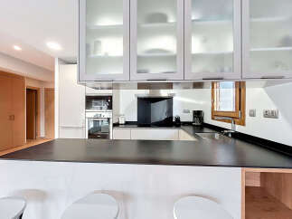 Discover modern living in this stylish kitchen! Featuring sleek cabinetry, a black countertop, and stainless steel appliances, this space is perfect for cooking and entertaining.
